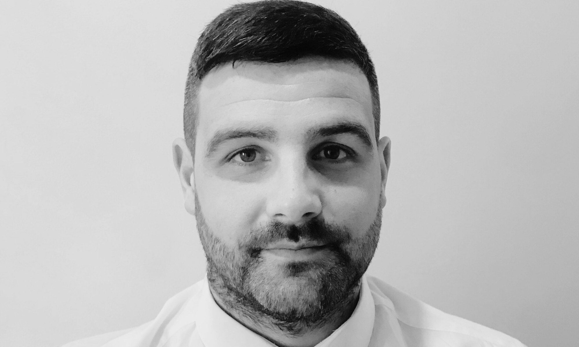 Black and white headshot of a man with a short beard